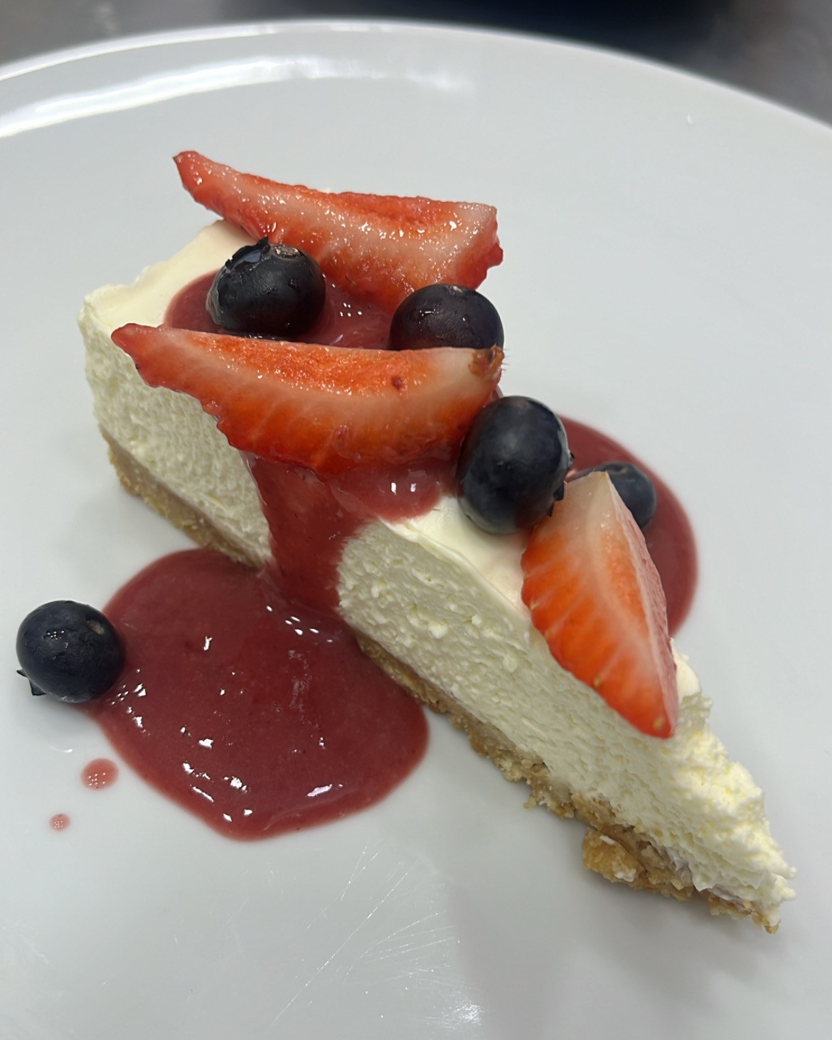 Cheesecake com calda de frutas vermelhas, morangos e mirtilos